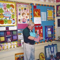 2/17/06 - Flag Day Program at Mission Educational Center for 211 students - Lion Bob Lawhon using the flag handout to tell students about the pledge of allegiance, facts about the flag, and the stars on the flag and the states they represent.
