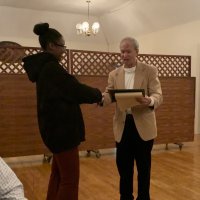 1/15/20 - Student Speaker Contest at the I.A.S.C - Topic: Homelessness in California: What is the Solution? - Lion Chairman Paul Corvi congratulating student speaker Xiomara Larkin and reading her first runner up certificate to the audiance.