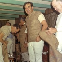 Early 1971 - Dress rehearsal for the District 4-C4 Convention in May at a member’s home - Member (blue shirt in back), member (bending putting on burlap sack), LJoe Giuffre (facing away from camera), Art Blum, and Bob Dobbins, all getting dressed for convention rehearsal.