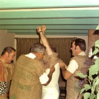 Early 1971 - Dress rehearsal for the District 4-C4 Convention in May at a member’s home - L to R: Frank Ferrera gets a good chuckle while Joe Giuffre and Art Blum help another member squeeze into his burlap sack.