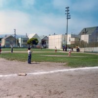 Oct 1975 - Excelsior Playground, Russia & Madrid - in conjunction with Beep Baseball - Pete Bello, second from light pole in background, looks on as children play t-ball.
