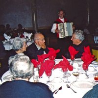 11/27/05 - 27th Annual Giulio Francesconi Charity Raffle Drawing at the Italian American Social Club -  Guest, on left, at the table with Helen and George Habeeb talking with Joe Farrah while accordionist John Fiore plays in the background.