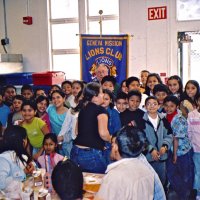 11/22/05 - Mission Educational Center, San Francisco - Students crowd in for a group shot with our Club banner. Lion Bob Lawhon patiently waits in front of the banner for them to get set.