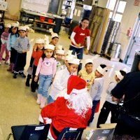 12/15/06 - Christmas at Mission Educational Center, Police Officer “Nacho” Martinez as Santa - Santa greeting each happy student and presenting them with a gift.