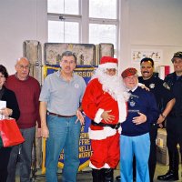 12/15/06 - Christmas at Mission Educational Center, Police Officer “Nacho” Martinez as Santa - L to R: Principal Deborah Molof, Lions Bill Graziano and Bob Fenech, Santa, Lion Bob Lawhon, and Santa’s Police Officer escorts.