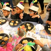 11/16/17 - Serving Thanksgiving Luncheon, Mission Educational Center - Immigrant students feast on lunch at their first Thanksgiving at Mission Education Center. (Mira Laing/Special to S.F. Examiner)