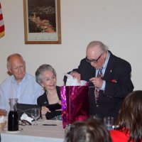 8-17-22 - 73rd Installation of Officers, Italian American Social Club - Bob Lawhon slowly opens his gift as Bill Graziano, Bill & Eleanor Britter, on left, and Rose Benavente, right, look on.