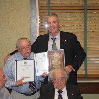 8-21-24 - 75th Installation of Officers, Basque Cultural Center, South San Francisco - Stephen Martin, right, with Bob Lawhon displaying his two albums and Past President’s plaque just received. Seated are Bill Graziano and Joe Farrah.