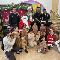 12-18-24 - 43rd Annual Lions Christmas with Santa at the Mission Education Center with Los Bomberos Firefighters - All the students pose with Santa, their teacher, her assistant, and members of Los Bomberos Firefighters.