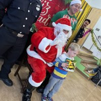 12-18-24 - 43rd Annual Lions Christmas with Santa at the Mission Education Center with Los Bomberos Firefighters - One by one, the students receive their presents from Santa, each having a quick pose after with Santa and his helper.