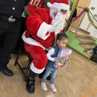 12-18-24 - 43rd Annual Lions Christmas with Santa at the Mission Education Center with Los Bomberos Firefighters - One by one, the students receive their presents from Santa, each having a quick pose after with Santa and his helper.