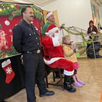 12-18-24 - 43rd Annual Lions Christmas with Santa at the Mission Education Center with Los Bomberos Firefighters - One by one, the students receive their presents from Santa, each having a quick pose after with Santa and his helper.