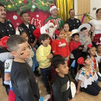 12-18-24 - 43rd Annual Lions Christmas with Santa at the Mission Education Center with Los Bomberos Firefighters - All the students pose with Santa, their teacher, and members of Los Bomberos Firefighters.